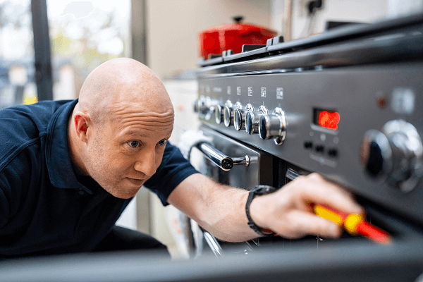 Male engineer fixing an oven