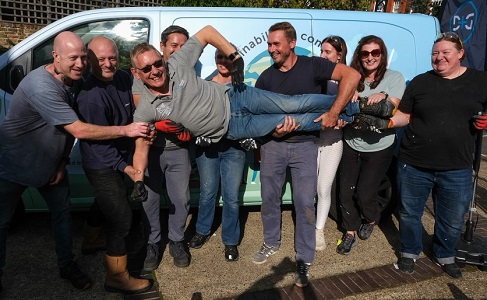 Domestic & General service director being held up by his team in front of the Van for Good