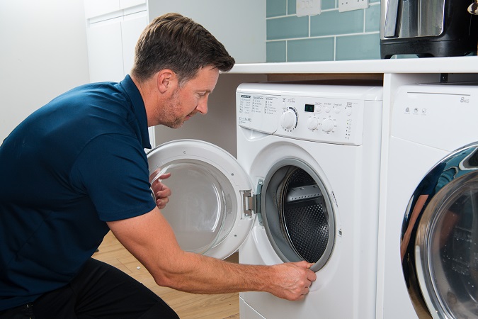 Photo of engineer repairing a washing machine