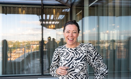 Woman standing on balcony drinking champagne