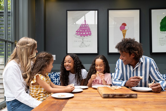 Family of five in kitchen laughing and smiling together