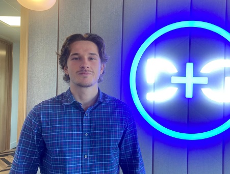 Man in blue shirt standing in front of blue D&G sign